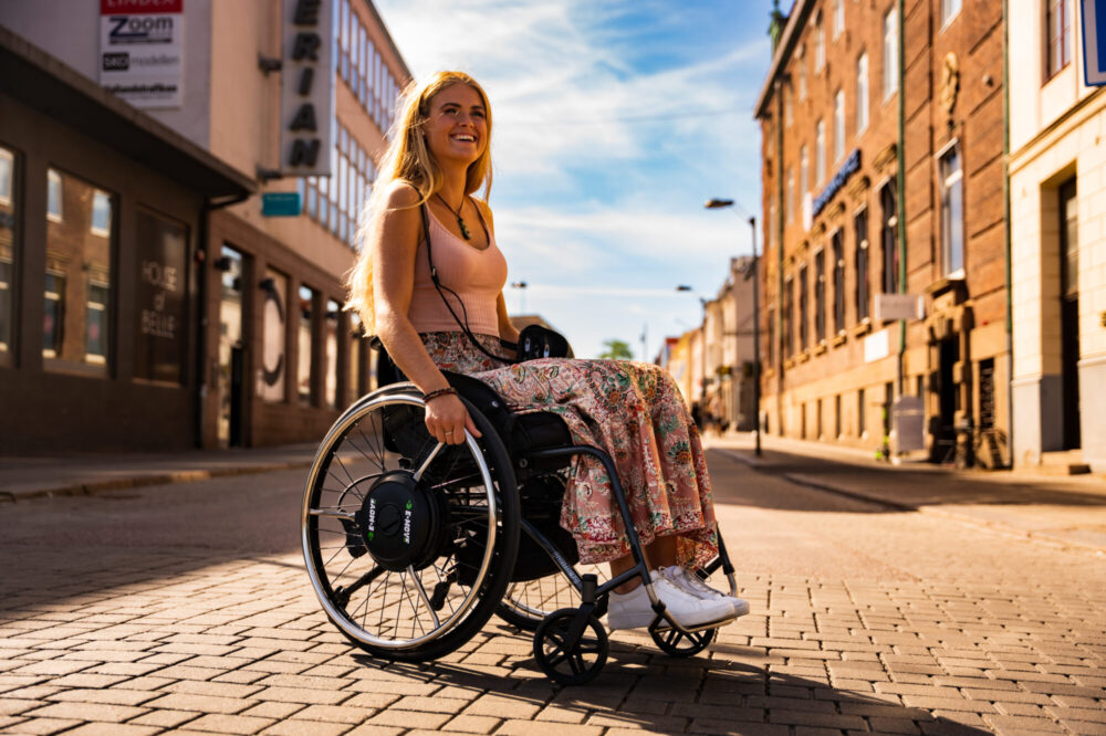 Woman in wheelchair with Decon E-Drive power unit attached to wheel